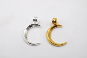Macro detail of S925 silver and gold moon pendants with hallmark stamps on hangers