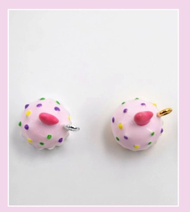 Detail view of pink resin cupcake charms with gold and silver metal rings for DIY jewelry
