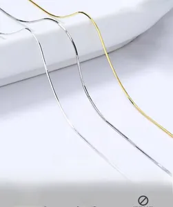 Macro shot of silver and gold S925 sterling silver snake bone chains on white background