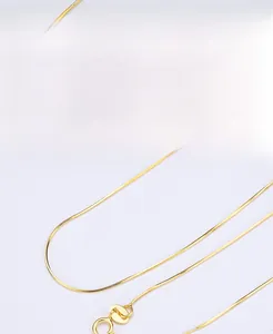 Detailed view of gold S925 sterling silver snake chain texture with needle end