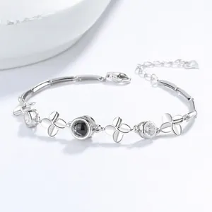 Macro detail of 925 silver clover bracelet with clear zircons and black center bead