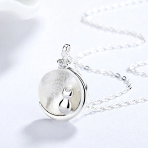 Macro detail of S925 sterling silver cat and moon pendant with shimmering pearl texture