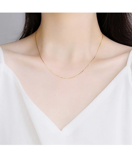 Close-up of a minimalist gold snake chain necklace elegantly worn on a woman neck