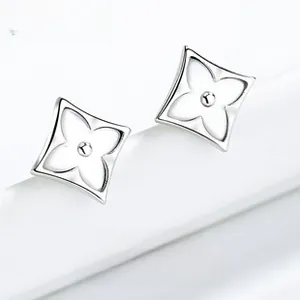 Macro shot of silver rhombic clover stud earrings with inlaid white mother of pearl