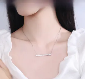 Detail of a 925 sterling silver long horizontal bar necklace with cubic zirconia