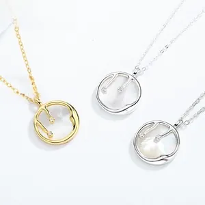 Détail de pendentifs ange en nacre avec design minimaliste en or et argent liquide