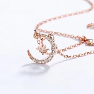 Detailed macro shot of rose gold crescent moon and star pendant with pavé diamonds