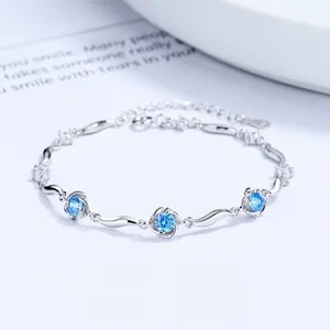 Detail of 925 silver bracelet featuring blue clover charms and sparkling accent stones