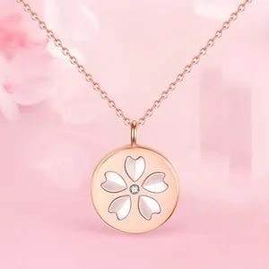 Détail du pendentif fleur de cerisier en or rose avec pétales de nacre et diamant central