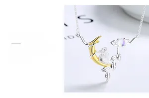 Detailed view of silver moon rabbit pendant featuring iridescent moonstone and gold moon
