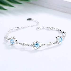 Detail of silver clover flower bracelet with sparkling sky blue cubic zirconia stones