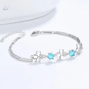 Close-up of S925 sterling silver clover bracelet with blue stones and a 925 stamp tag