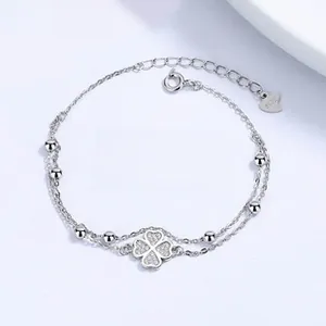 Macro detail of S925 sterling silver double-layer bracelet with clover pavé charm