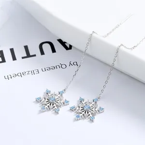 Close-up of S925 sterling silver snowflake earrings with blue zircon crystals on a long chain