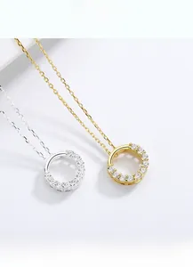 Detail of round S925 silver pendant necklaces with zircon inlay in gold and silver finish
