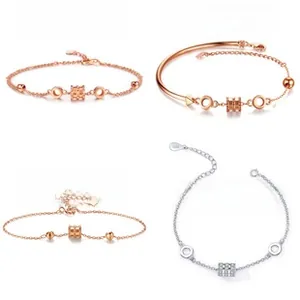 Detail view of four rose gold and silver S925 sterling silver cylinder charm bracelets