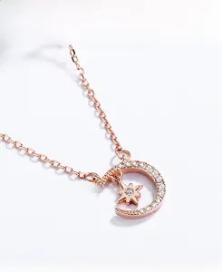Vue macro du collier lune et étoile doré rose avec incrustation de zircon blanc