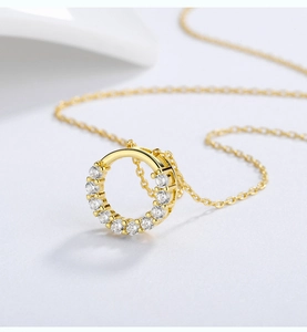 Close-up of golden necklace pendant featuring eleven sparkling zircons on an O-chain
