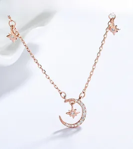 Vue macro du pendentif lune et étoile en or rose avec des pierres scintillantes