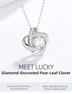 Detailed close-up of 925 silver clover pendant with zircon inlay on sand surface