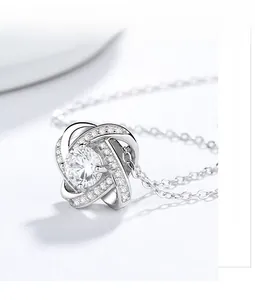 Macro detail of 925 silver clover pendant with central zircon and pavé setting
