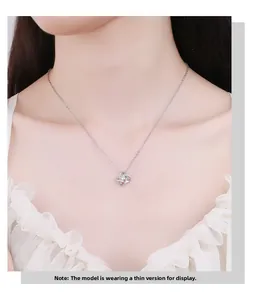 Macro shot of 925 sterling silver four-leaf clover pendant on model's neck thin chain