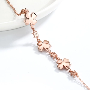 Detailed close-up of rose gold four-leaf clover bracelet with white zircons and fine links