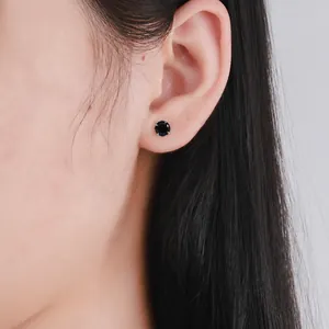 Close-up of a 925 silver stud earring with a four-prong set round black zircon on ear