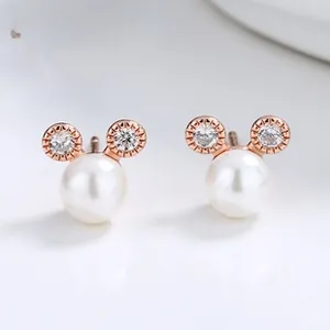 Detailed close-up of Mickey-shaped pearl earrings with rose gold and sparkling zircon stones
