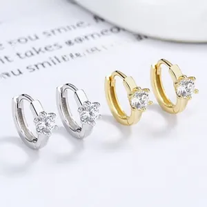Detail view of 925 silver six-claw zircon huggie hoop earrings in gold and silver finish