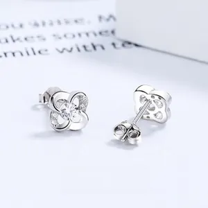Macro shot of 925 sterling silver four-leaf clover earrings with sparkling cubic zirconia