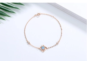 Nahaufnahme des roségoldenen Kleeblatt-Armbands mit blauem Zirkon und feiner Kette