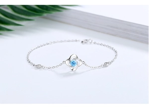 Details des Kleeblatt-Armbands aus Silber mit blauem Stein und weißen Zirkonia