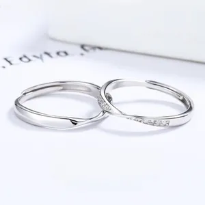 Detail of Mobius loop couple rings featuring one zircon-inlaid and one sleek silver band
