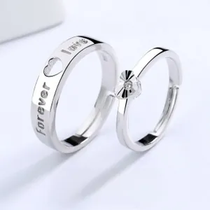 Close-up of Mobius couple rings featuring heart cut stone and Forever Love engraving