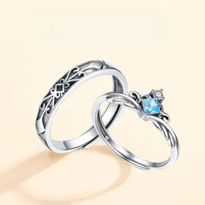 Close-up of S925 silver couple rings featuring a crown with blue stone and knight engraving