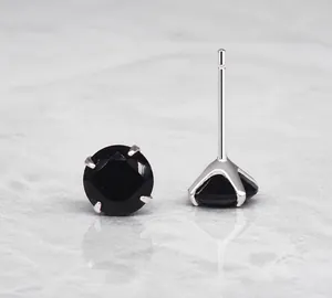 Macro detail of 925 silver stud earrings featuring black round-cut cubic zirconia