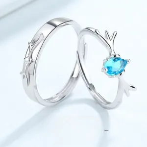 Detailed shot of S925 silver couple rings featuring deer antlers and a pear-cut blue gem