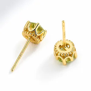 Macro view of 925 silver gold-plated crown earrings with green peridot gemstone and S925 hallmark
