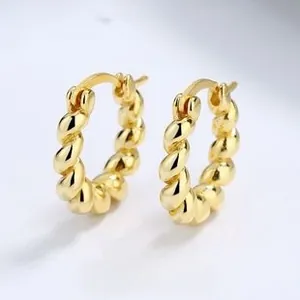 Macro shot of thick gold twisted rope hoop earrings with detailed metallic texture