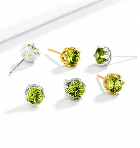 Macro shot of 925 silver crown stud earrings with natural green peridot crystals