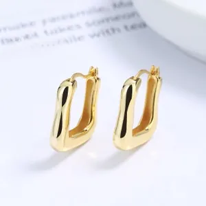 Detail of high-polished golden irregular wavy rectangular stud earrings in 925 silver