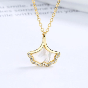 Vue macro du collier feuille de ginkgo doré avec nacre blanche et pierres de zircone