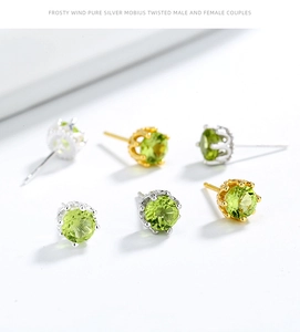 Macro shot of crown-setting peridot earrings in sterling silver showing luxury green crystals