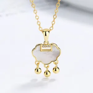 Macro shot of gold Ruyi lock pendant with white mother of pearl and small bell charms