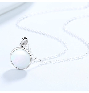 Gros plan d'un collier en argent S925 avec pendentif circulaire en nacre blanche