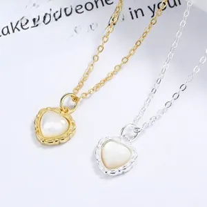 Detail of silver and gold heart pendants with mother of pearl inlays on O-shaped chains