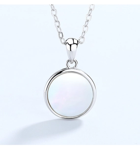 Gros plan d'un collier en argent S925 avec pendentif circulaire en nacre blanche