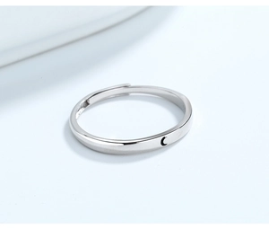Detail of adjustable silver ring with minimalist black crescent moon motif on white background
