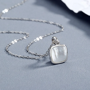 Collier minimaliste en argent S925 avec pendentif carré en nacre sur papier bleu